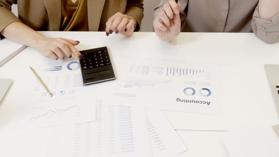 Financial documents, charts, and a calculator on a desk